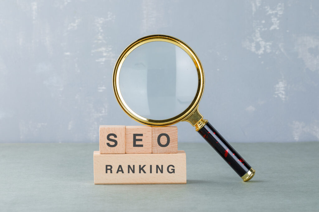 conceptual of seo analysis and business. with wooden blocks with words on it, magnifying glass on sage color background side view. horizontal image